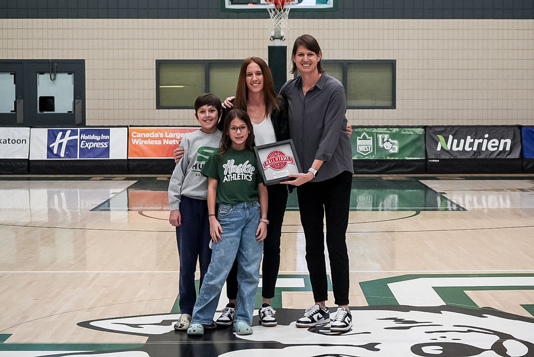  Jacqueline Lavallee and her children with Huskie women’s basketball coach Lisa Thomaidis during the Nov. 16 game when Lavallee was honoured for her Canada West Hall of Fame induction. (Photo: Huskie Athletics) 